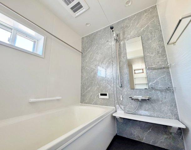 マーブル調の壁と清潔感ある空間が、日常の疲れを癒す穏やかなひとときを演出。窓から自然な光が差し込み、心地よいバスタイムを予感させます。