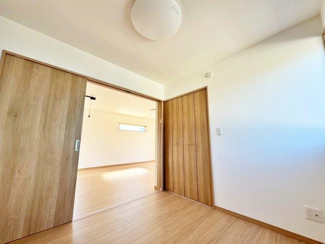 木目の風合いが温もりを感じさせ、心地よい開放感を演出する空間。隣室へと続く滑らかな動線が、暮らしにゆとりをもたらします。リビング横の洋室は、来客用の部屋や在宅ワークの空間としても活用できます。